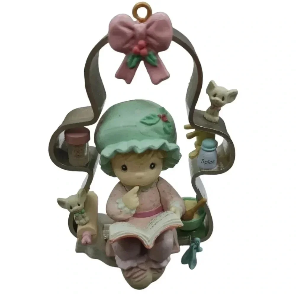 Precious moments girl perched on a cookie cutter christmas ornament
